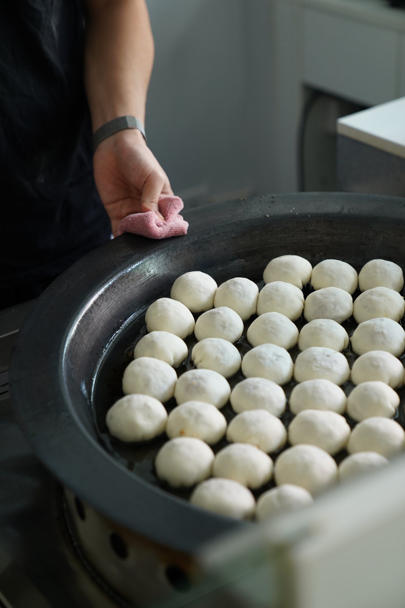 Những chiếc Sheng Jian Bao chờ lên chảo — vỏ mỏng, nhân mọng, chưa qua lửa.